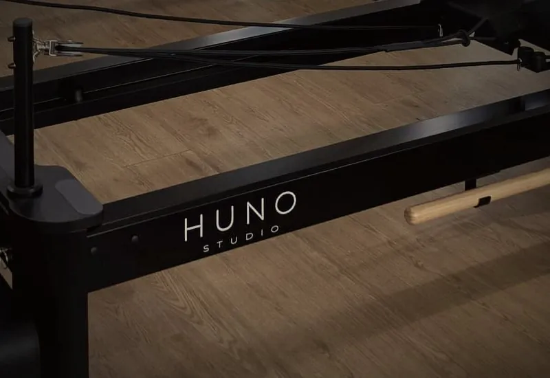 The HUNO Studio name on a black reformer frame